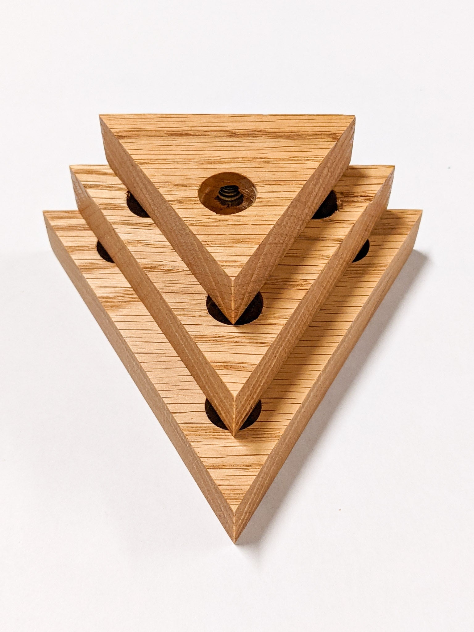 A set of three triangle propagation shelves sit one on top of the other with the largest at the bottom and the smallest on top.